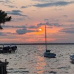 Boats on the water during an orange sunset