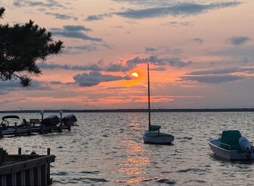 Boats on the water during an orange sunset
